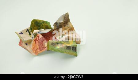 Un mucchio di banconote in euro sbriciolate su sfondo grigio. Minimalismo, concetto. Foto Stock