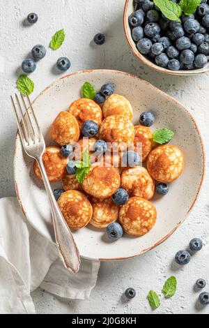 Mini pancake deliziosi fatti in casa con frutta dolce. Colazione con mini pancake e frutti di bosco. Foto Stock