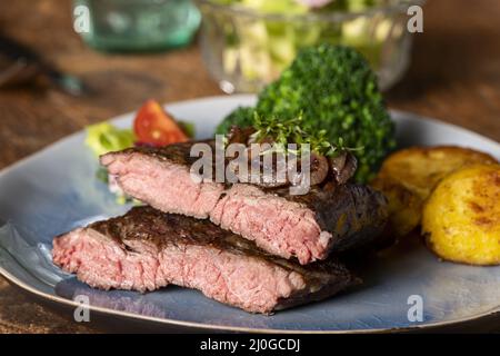 Metà di una bistecca sul piatto Foto Stock