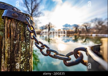 Vecchio molo in legno con catena Foto Stock