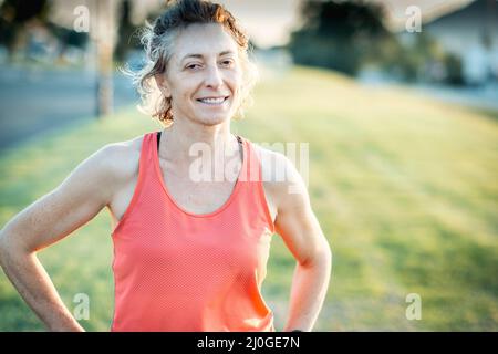 Vera giovane matura donna caucasica in un abbigliamento sportivo nel parco in un pomeriggio soleggiato. Foto Stock