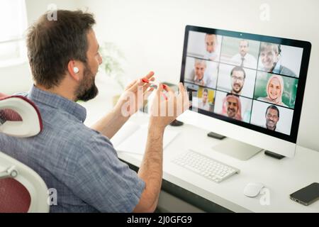 Uomo adulto medio che ha una conferenza online di lavoro da casa Foto Stock