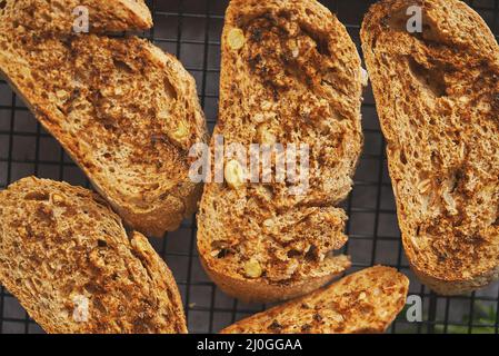 Primo piano di marcor shot delle fette di baguette tostate poste sul telaio della griglia. Vista dall'alto Foto Stock