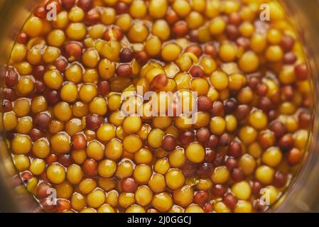 Senape francese con semi interi servita in vasetto di vetro. Messa a fuoco selettiva Foto Stock