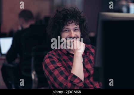 Un uomo d'affari sorridente che indossa cuffie con microfono e che ha una chiamata di gruppo di riunione virtuale che chiacchiera con persone diverse nell'assistenza clienti. Videochiamata in conferenza attiva Foto Stock