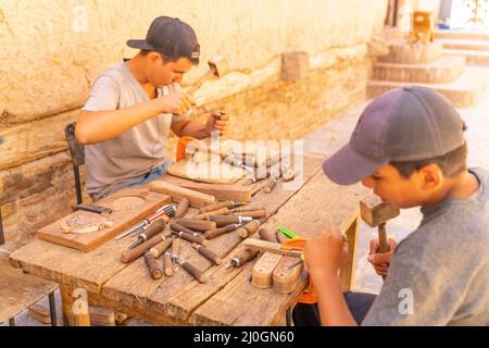 Khiva/Uzbekistan:08.20.2019-i giovani maestri del legno al lavoro Foto Stock