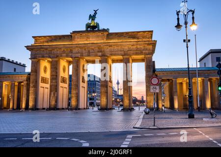 La porta di Brandeburgo con la torre della televisione all'alba, vista a Berlino, in Germania Foto Stock