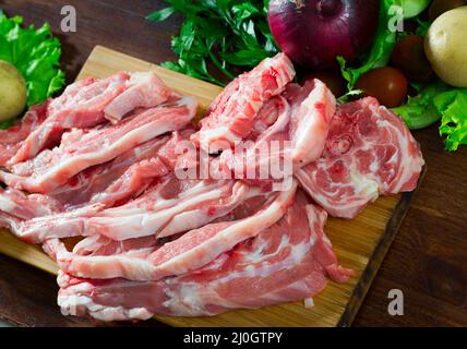 Assortimento di agnello crudo e verdure su scrivania in legno naturale Foto Stock