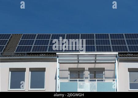 Moduli solari sul tetto di un edificio di appartamenti Foto Stock