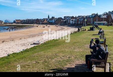 North Berwick, East Lothian, Scozia, Regno Unito, 19th marzo 2022. UK Meteo: Colori ucraini. In una luminosa giornata di primavera con una brezza dura e una temperatura fredda, North Berwick mostra la sua solidarietà con l'Ucraina in diverse località intorno alla città balneare. Nella foto: La bandiera Ucraina vola accanto a West Beach Foto Stock