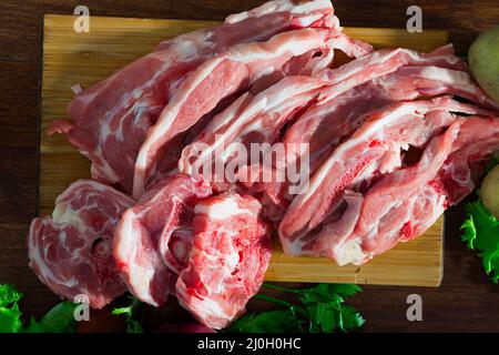 Assortimento di agnello crudo e verdure su scrivania in legno naturale Foto Stock