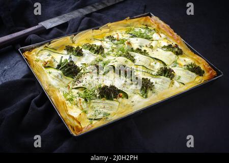 Il tradizionale tarte francese con zucchine e broccoli per bambini è servito come primo piano in forma di supporto Foto Stock