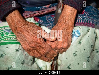 Primo piano delle lancette incrociate di una nonna più anziana nepalese. Foto Stock