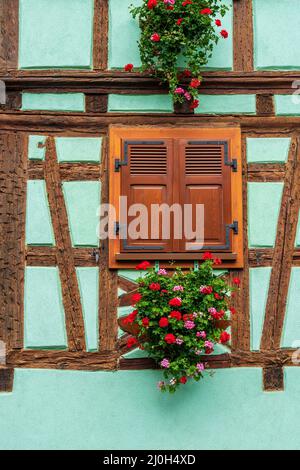 Finestra decorare con fiori su vecchia casa con struttura in legno Foto Stock