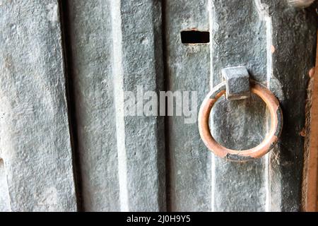 Vecchia porta arrugginita in metallo con pomello Foto Stock