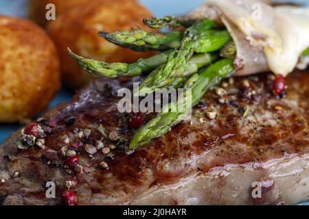 Asparagi verdi su una bistecca Foto Stock