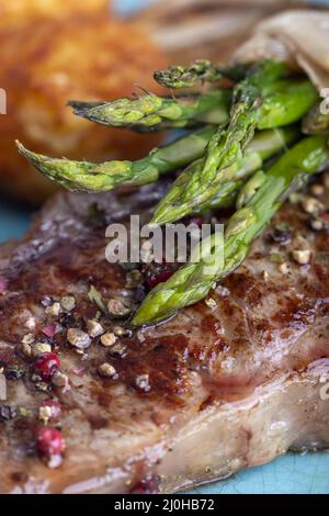 Asparagi verdi su una bistecca Foto Stock