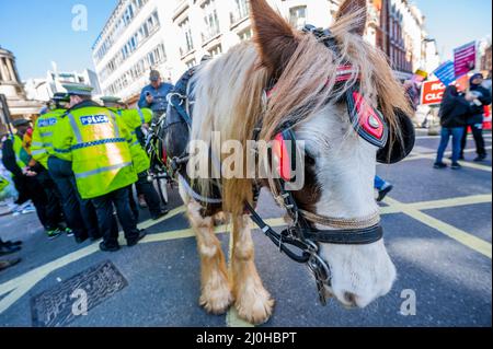 Londra, Regno Unito. 19th Mar 2022. I viaggiatori Rom con i loro cavalli e le carrozze si uniscono alla protesta, ma alla fine vengono invitati a spostarsi dalla polizia, per timore che i loro cavalli possano imbavagliarsi a causa delle sirene della polizia - come parte di una manifestazione nazionale una marcia contro il razzismo nella Giornata ONU contro il razzismo del 2022. La marcia inizia fuori dalla BBC su Langham Place ed è stato organizzato da Say No al razzismo sostenuto da diversi sindacati. Credit: Guy Bell/Alamy Live News Foto Stock