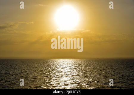 Tramonto dorato sole sul mare. I raggi del sole si infrangono attraverso le nuvole. Magnifico mare. Spazio di copia. Foto Stock