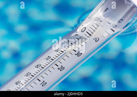 Misurare la temperatura nella piscina con un termometro Foto Stock