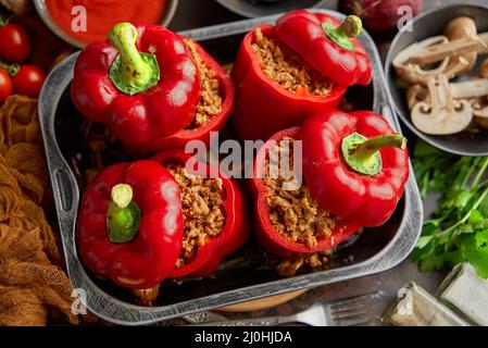 Peperoni rossi dolci ripieni di carne e pomodoro in un vassoio di frittura vintage vista dall'alto Foto Stock