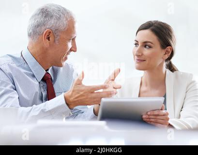 Tecnologia che supporta i processi aziendali. Scatto ritagliato di due colleghi che utilizzano un tablet digitale al lavoro. Foto Stock