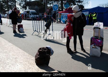 18 marzo 2022, Siret, Romania: Una madre abbraccia la figlia mentre si riposano dopo aver attraversato il confine con Siret. Circa 3 mila persone arrivano ogni giorno a Siret, in Romania, per rifugiarsi dalle violenze causate dalla guerra tra Russia e Ucraina. In questa città di confine è stato organizzato un corridoio di aiuti umanitari tra varie organizzazioni civili e statali. Le persone che fuggono dall'Ucraina sono principalmente donne, bambini e adulti anziani. Quando si attraversa la frontiera, le persone ricevono assistenza medica, psicologica, alimentare, di trasporto e alloggio. Grazie all'aiuto dei volontari, queste persone possono fare una pausa e una ga Foto Stock