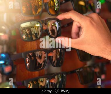 Mi piace questo. Scatto corto di un uomo che prova sugli occhiali da sole ad una stalla. Foto Stock