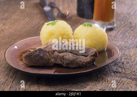 Maiale arrosto con gnocchi di patate Foto Stock