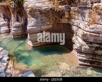 Fiume tranquillo con un fondo roccioso circondato da canyon ad alto rilievo, coltivato a muschio Foto Stock