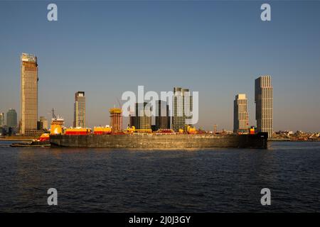 Tugboat spingendo una petroliera fino al fiume East a Long Island City Queens Waterfront a New York Foto Stock