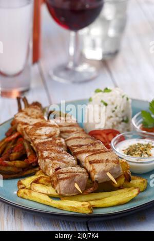 Spiedini di souvlaki greci con patatine fritte Foto Stock