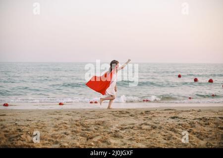 Capretto supereroe contro il cielo blu sfondo. Concetto di gioia e infanzia Foto Stock