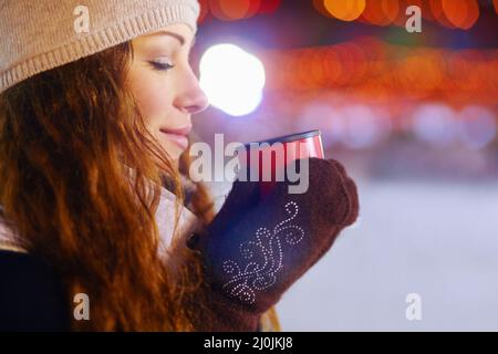 Aah, quella sensazione quando la prima tazza di caffè tocca la tua anima..... Scatto di una bella giovane donna che gode di una bevanda calda all'aperto. Foto Stock