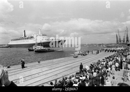 Il QE2 torna a casa a Southampton. Union Jacks è festooned sulle automobili, drappeggiato sulle spalle, ondulato sui bastoni. Southampton dà il benvenuto a "Three Cheers" al QE2 lussuoso liner trasformato in trooper di ritorno dalla guerra. A bordo è il suo prezioso carico, i 700 sopravvissuti della HMS Coventry, ardent e Antelope, affondati nella battaglia per le Falklands. 11th giugno 1982. Foto Stock