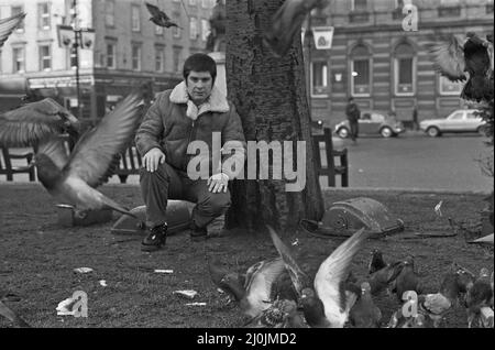 Black Sabbath piombo cantante Ozzy Osborne con capelli corti, nutrendo i piccioni in George Square di Glasgow.29th novembre 1982. Foto Stock