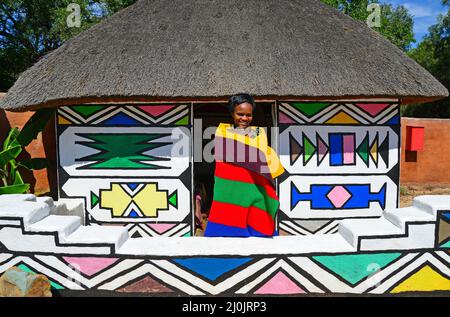 Ndebele donna e capanna a Motseng Villaggio Culturale, Sun City Resort, Pilanesberg, nord ovest della provincia, Repubblica del Sud Africa Foto Stock