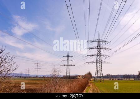 Riprese di droni di linee elettriche e di molti poli di potenza nell'ambiente rurale della Germania Foto Stock