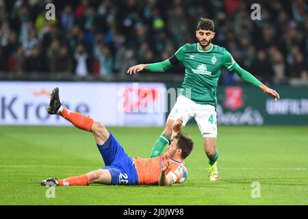 Brema, Germania. 19th Mar 2022. Calcio: 2nd Bundesliga, Werder Bremen - Darmstadt 98, Matchday 27, wohninvest Weserstadion. Eren Dinkci (r) di Werder combatte per la palla contro Matthias Bader di Darmstadt. Credito: Carmen Jaspersen/dpa - NOTA IMPORTANTE: In conformità con i requisiti della DFL Deutsche Fußball Liga e della DFB Deutscher Fußball-Bund, è vietato utilizzare o utilizzare fotografie scattate nello stadio e/o della partita sotto forma di immagini di sequenza e/o serie di foto video-simili./dpa/Alamy Live News Foto Stock