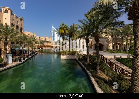 Burj al Arab vista da Madinat Jumeirah. Architettura di stile Arabo tradizionale. Emirati Arabi Uniti. Medio Oriente. Foto Stock