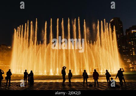 Sagome di persone godendo la fontana show di Dubai di notte, Emirati Arabi Uniti Foto Stock