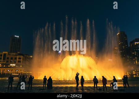 Sagome di persone godendo la fontana show di Dubai di notte, Emirati Arabi Uniti Foto Stock