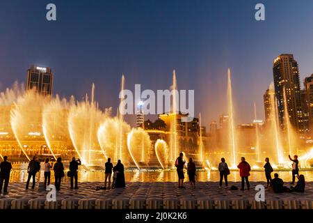 Sagome di persone godendo la fontana show di Dubai di notte, Emirati Arabi Uniti Foto Stock