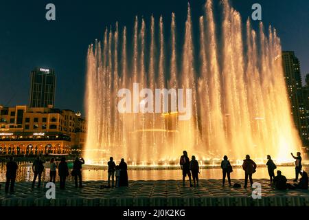 Sagome di persone godendo la fontana show di Dubai di notte, Emirati Arabi Uniti Foto Stock