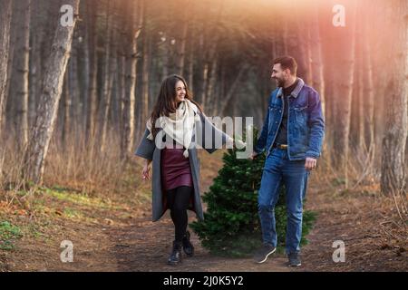 Coppia allegra con albero di abete rosso in legno Foto Stock