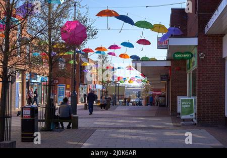 Appendere un ombrello colorato in centro città Foto Stock