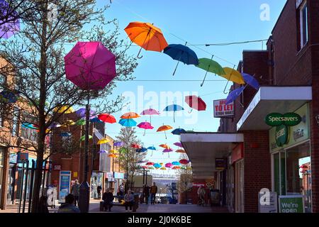 Appendere un ombrello colorato in centro città Foto Stock