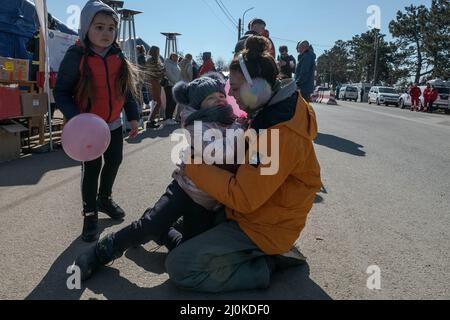 18 marzo 2022, Siret, Romania: Magda, un volontario umanitario abbraccia e gioca con i bambini che attraversano il confine con le loro famiglie. Circa 3 mila persone arrivano ogni giorno a Siret, in Romania, per rifugiarsi dalle violenze causate dalla guerra tra Russia e Ucraina. In questa città di confine è stato organizzato un corridoio di aiuti umanitari tra varie organizzazioni civili e statali. Le persone che fuggono dall'Ucraina sono principalmente donne, bambini e adulti anziani. Quando si attraversa la frontiera, le persone ricevono assistenza medica, psicologica, alimentare, di trasporto e alloggio. Grazie all'aiuto dei volontari, Th Foto Stock