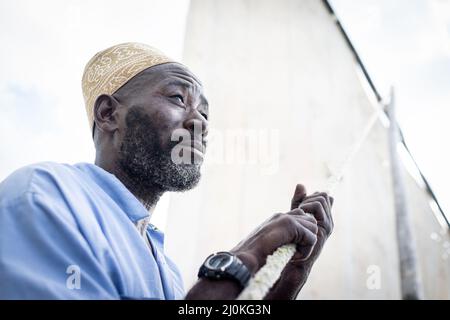 Uomo anziano nero che naviga in barca Foto Stock