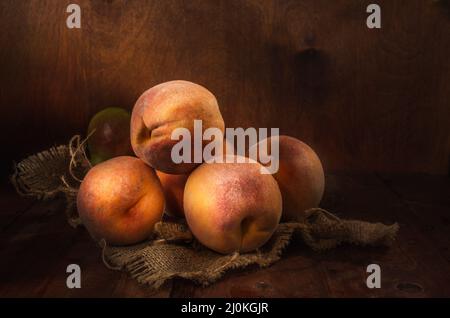 Pesche in gruppo su sfondo di legno scuro in stile rustico Foto Stock